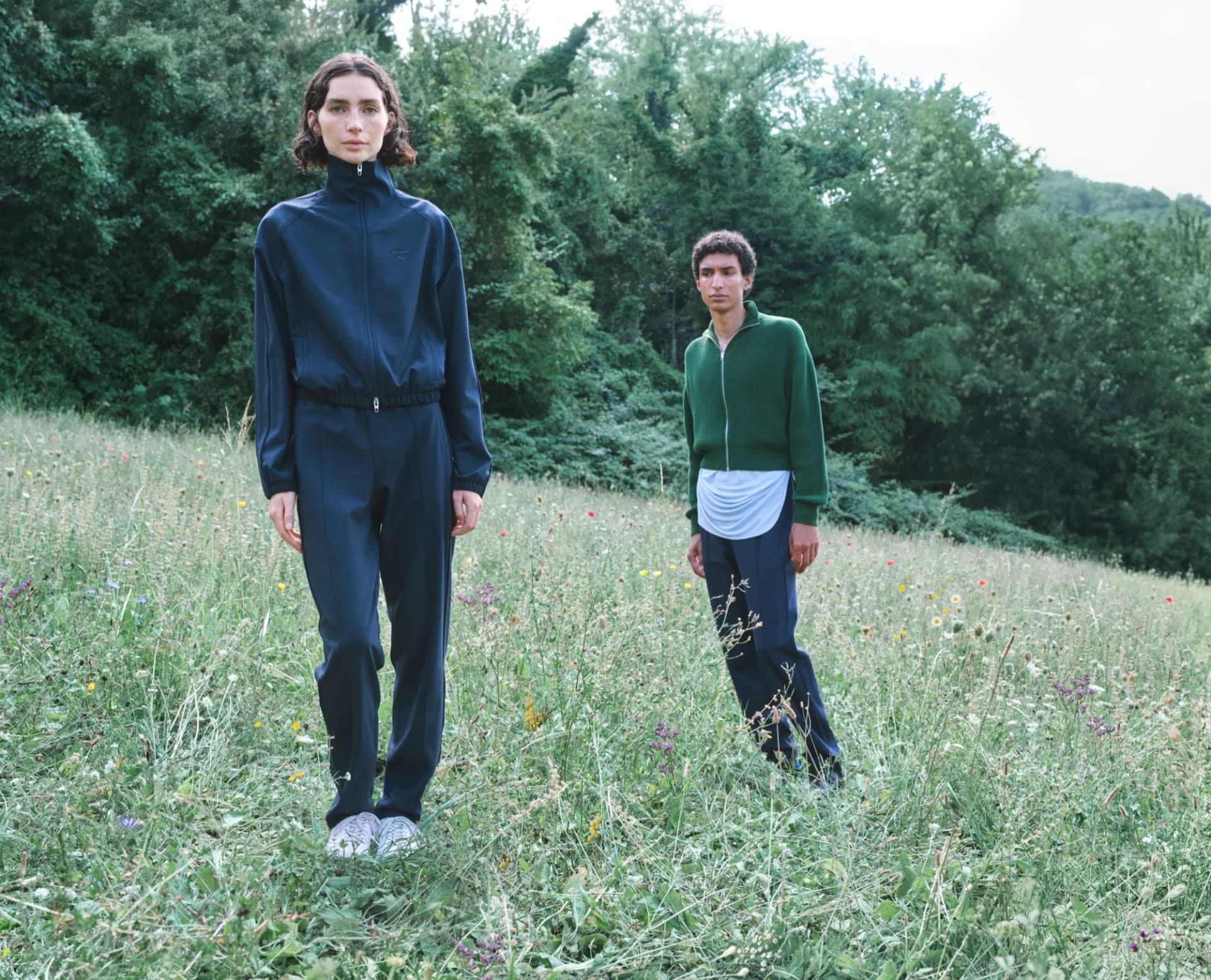 Meadow Walker and Barry Lawson wear PUMA and Jil Sander campaign looks in a grassy landscape